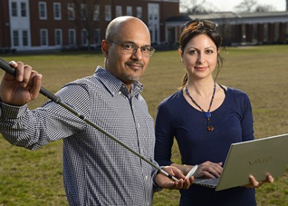 Researchers pose with golf club, laptop computer