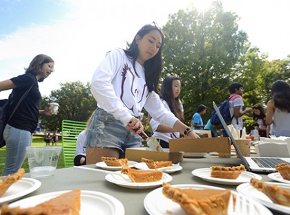 A student dishes out slices of pumpkin pie