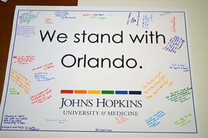 a poster reading 'We stand with Orlando' signed in rainbow-colored pens