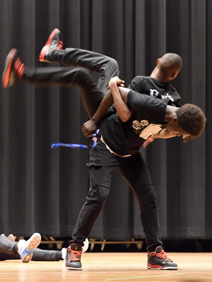A student flips another student across his back