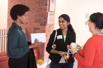 Three young women talk during break in symposium