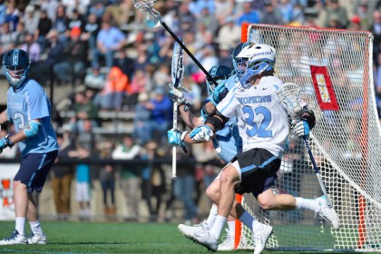 JHU lacrosse player drives towards the net