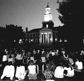 Black and white photo of a group of people sitting on the quad
