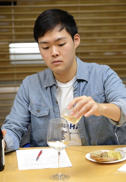 Student pouring wine sample into glass