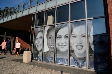 Window panels of the Mattin Center feature black and white clings of women's portraits
