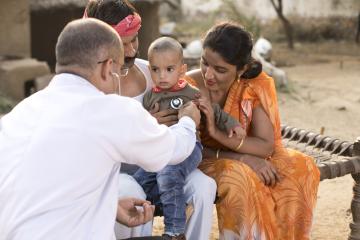 A doctor uses a stethoscope on a young Indian boy