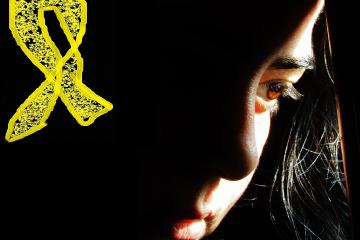 A moody, dark photograph of a sad person superimposed with a drawing of a yellow ribbon, a symbol of suicide prevention activism