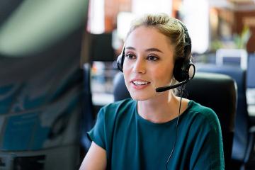 A woman talking on a telephone headset