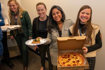 CTY executive director Amy Shelton, Tricia Schellenbach, Arpan Munier, and Emily Delinski showing their pizza to the camera