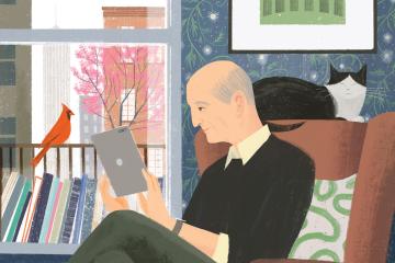 Image of an older man sitting in an armchair while reading on his iPad