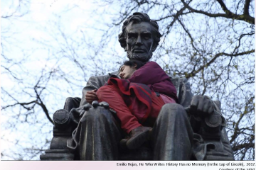 Photograph of a young man sitting in the lap of a statue of Abraham Lincoln as if a child. Caption: Emilio Rojas, He Who Writes History Has No Memory (in the Lap of Lincoln), 2017. Courtesy of the artist.