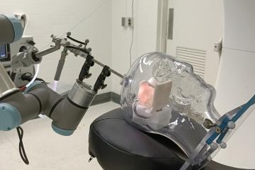 A robotic surgical device demonstrates a brain operation technique on a clear mannekin head