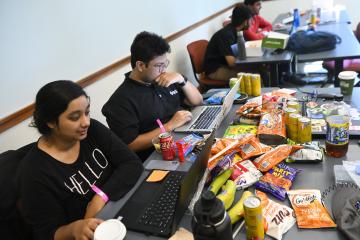 HopHacks students with laptops and a tableful of snacks