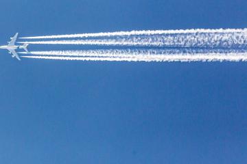 our engined airplane during flight in high altitude with condensation trails