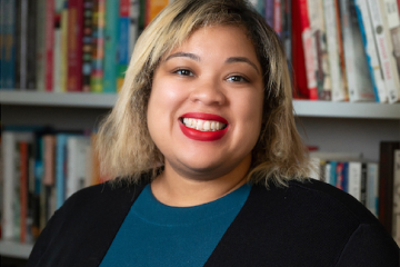 Photo of Danielle Evans, a Black woman, in front of a bookshelf