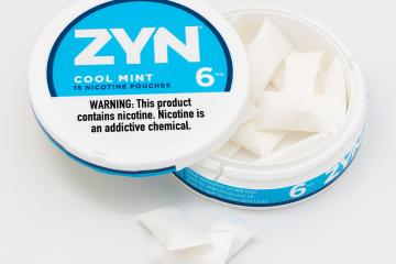 A tin of Zyn pouches with a light blue and white label