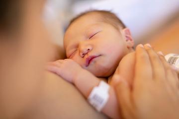 Newborn asleep on his mother's bare chest