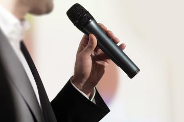 A closeup of a man speaking into a microphone