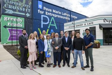 A group gathers for a photo outside the newly dedicated Pava Marie LaPere Center for Entrepreneurship, formerly FastForward U