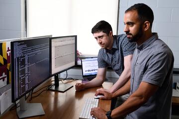 Dylan Taylor (left) and Rajiv McCoy looking into a dataset of genetics data in their computational biology lab. 
