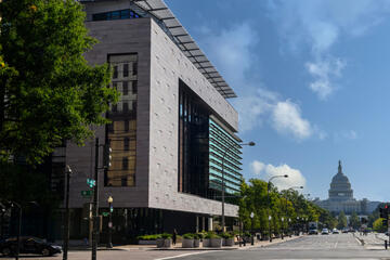 A building exterior with the U.S. Capitol dome in the background