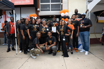 A group photo with Baltimore Mayor Brandon Scott celebrating a year without homicides in three Safe Streets neighborhoods