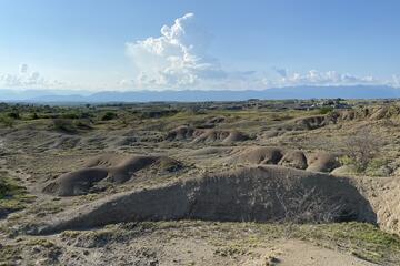 A dusty, hilly field in Colombia on a sunny day