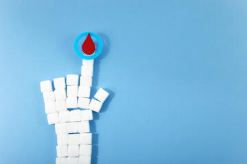 A hand made of sugar cubes with a blood drop above the pointer finger