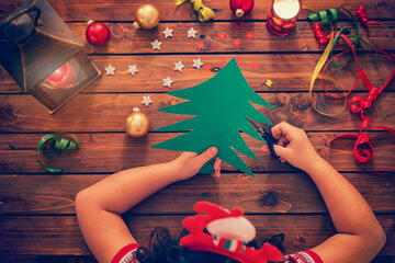 Child working at a crafts table with holiday-themed materials