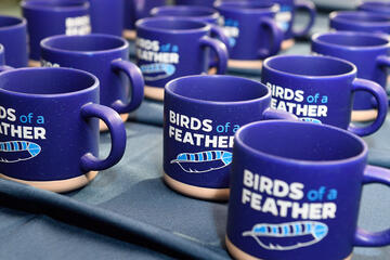 Mugs that say Birds of a Feather with a drawing of a feather