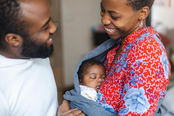 Mother and father smile at their newborn