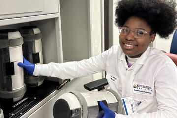 An intern in the 2023 program handles large equipment in a Pathology lab.