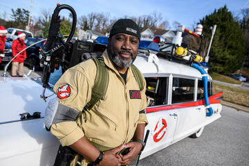 Charm City Ghostbuster Jarron Jackson with the team's car, a customized 1962 Cadillac hearse.