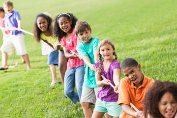 Group of children pulling a thick rope in a game of tug of war.