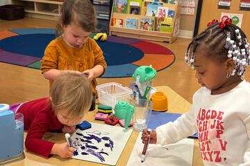 Three toddlers drawing with markers