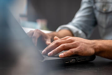 Man's hands on a laptop keyboard