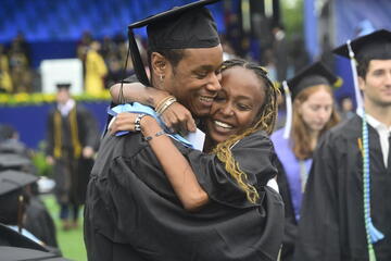 Two graduating students hug each other at JHU Commencement 2025.