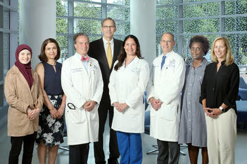 A team of eight people pose for a photo
