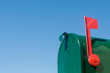 Rural mailbox with flag raised to indicate mail inside