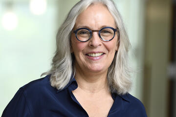 Photo of Gillian K. Hadfield, a while woman with light grey, shoulder-length hair and dark-framed glasses