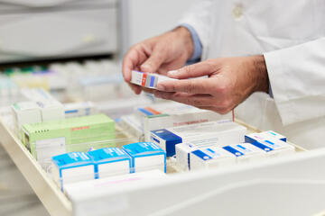 Pharmacist looking at items in a drawer to fulfill an order