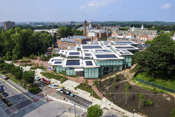 An aerial shot of a large building situated among red brick paths on a college campus