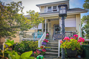 A house in Hamilton, one of the Northeast Baltimore neighborhoods on the Oct. 4 Trolley Tour route. It has a charming front porch and has many pots of colorful flowers.