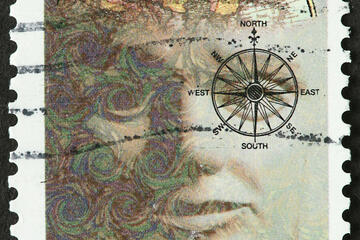A used stamp that reads "Fulbright Scholarships, USA 32." On it is an abstract depiction of a man with a map in his brain and a compass over his eye.