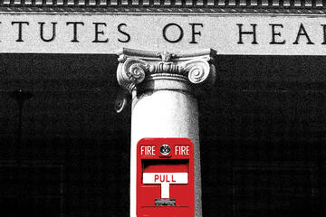 A black and white photo of a pillar on the NIH building. On the pillar is a red fire alarm.