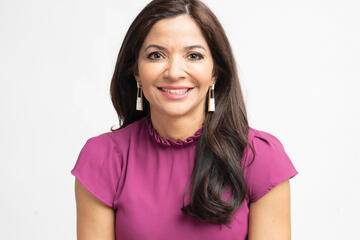 Photo of Selena Rezvani, who has long, dark hair and is wearing a pink shirt