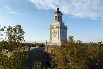 The Gilman Hall clock tower photographed on a sunny autumn day.
