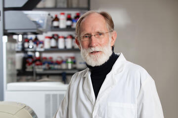 Peter Agre wearing a white lab coat in a lab setting