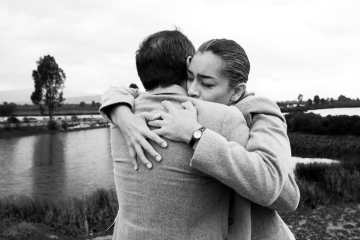 Black-and-white film still from "Dead Man's Switch" showing a woman hugging a man outdoors.