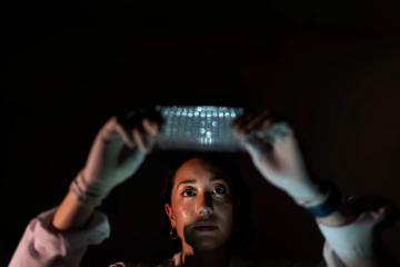 Researcher Kathryn Luly poses for a portrait holding a plate of mice cell samples in a biomedical engineering lab at Johns Hopkins University in Baltimore, Md., May 13, 2025. (AP Photo/David Goldman)